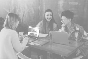 Students sitting around computers and laughing
